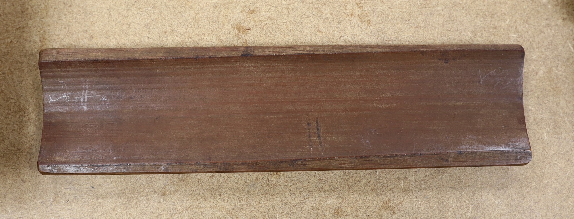 A Chinese bamboo inscribed wrist rest, carved in relief with columns of calligraphy, 30cm wide